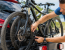 Homme en train de sangler des vélos sur un porte-vélos à l’arrière d’une voiture